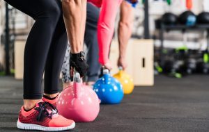 Veterans having functional fitness training with kettlebell in sport gym