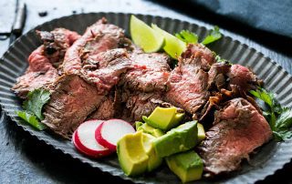 A large plate of carne asada and beets and avocado