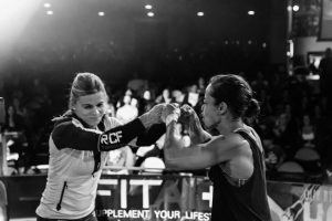 FiTness Testimony from a Professional Athlete, two female athletes fist bumping before a workout where they will go head to head