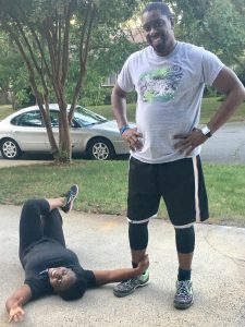Pastors already seeing transformation from Pastor Training Program, Pastor Theo standing with his wife laying on the ground post workout