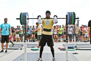 This is a super fit Christian leader you MUST get to know, crossfit competitor front squatting in a yellow tshirt, black shorts and sunglasses