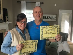 Today's Spotlight Athlete, Pastor Brent Watts, pastor brent in a blue t-shirt and Paula in a blue shirt with white vest holding their completion certificates smiling