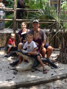 One FiT Pastor, Pastor Ken Schmidt, Ken with family sitting on a fake crocodile at the zoo