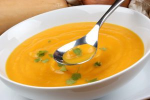 Foodie Friday - Butternut Squash Soupm a picture of a white ceramic bowl of orange butternut squash soup with a ladle in it