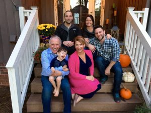 Testimony Tuesday - National Speaker, Zoe Elmore, picture of a whole family sitting on the from porch stairs, Zoe is in pink with her family surrounding her