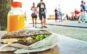 Travel eating, burger on a table alongside the boardwalk