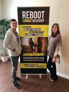 Testimony from Combat Warrior, Matthew Thomas, Matthew and his wife each standing on a side of the Reboot sign