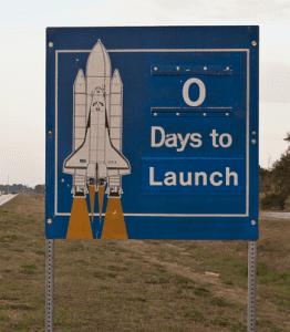 Happy Launch Day! Picture of a highway sign with a rocket ship and the words beside it "0 days to Launch"