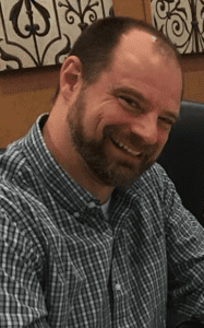 The Amazing Amick - Carmel Baptist Pastor FiTestimony, headshot of Pastor Jeremy in a plaid dress shirt smiling