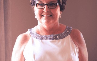 Testimonial - Kelly Morenus, Kelly smiling in a white dress