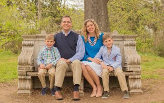 Testimony Tuesday with Emily Massey, Emily in a blue top with her family sitting on a bench